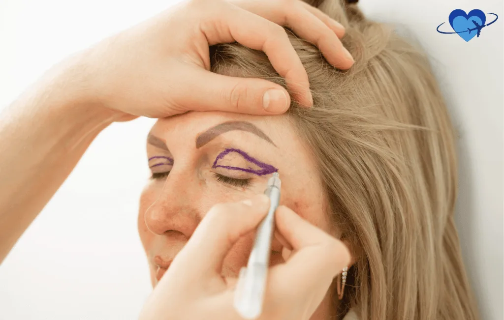 A person delicately marks another's eyelids with purple lines using a pencil, skillfully guided by hands. A heart and plane logo in the corner suggests a Colombia connection, echoing precision akin to an eye lift procedure.