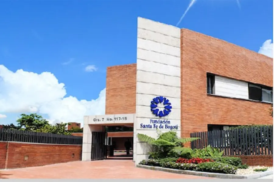 Vista exterior del edificio de la Fundación Santa Fe de Bogotá, con un cielo azul y algunas nubes al fondo; un emblemático centro de referencia en América Latina, reconocido por sus servicios médicos de vanguardia, entre los que se incluyen opciones competitivas de precios para la resonancia magnética de cuerpo completo.