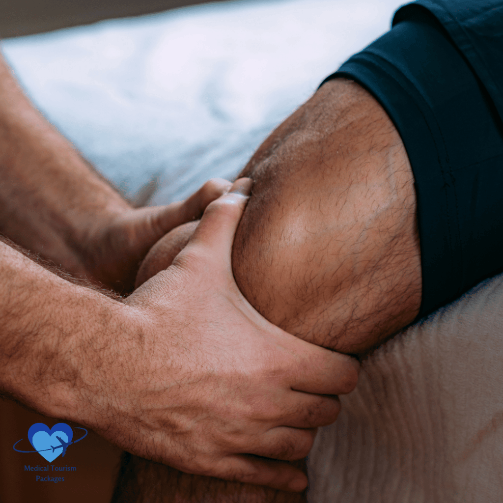 Una persona recibe un masaje de rodilla, haciendo hincapié en las manos y la rodilla, con un logotipo en la esquina inferior izquierda. Esta técnica relajante, arraigada en la medicina deportiva, favorece la recuperación y ayuda a volver al juego.