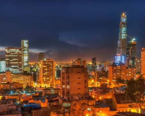 A person using an eye examination device is overlaid with a cityscape at dusk, featuring lit skyscrapers and busy roadways, capturing the allure of medical tourism as cutting-edge care meets vibrant urban exploration.